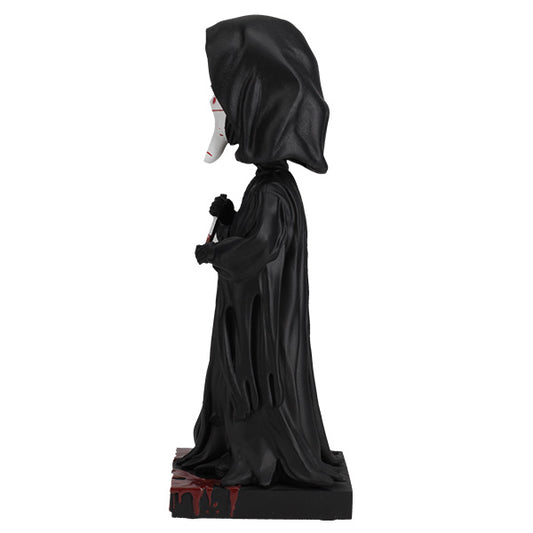 Statue of a hooded figure in black robes with a white face on a white background