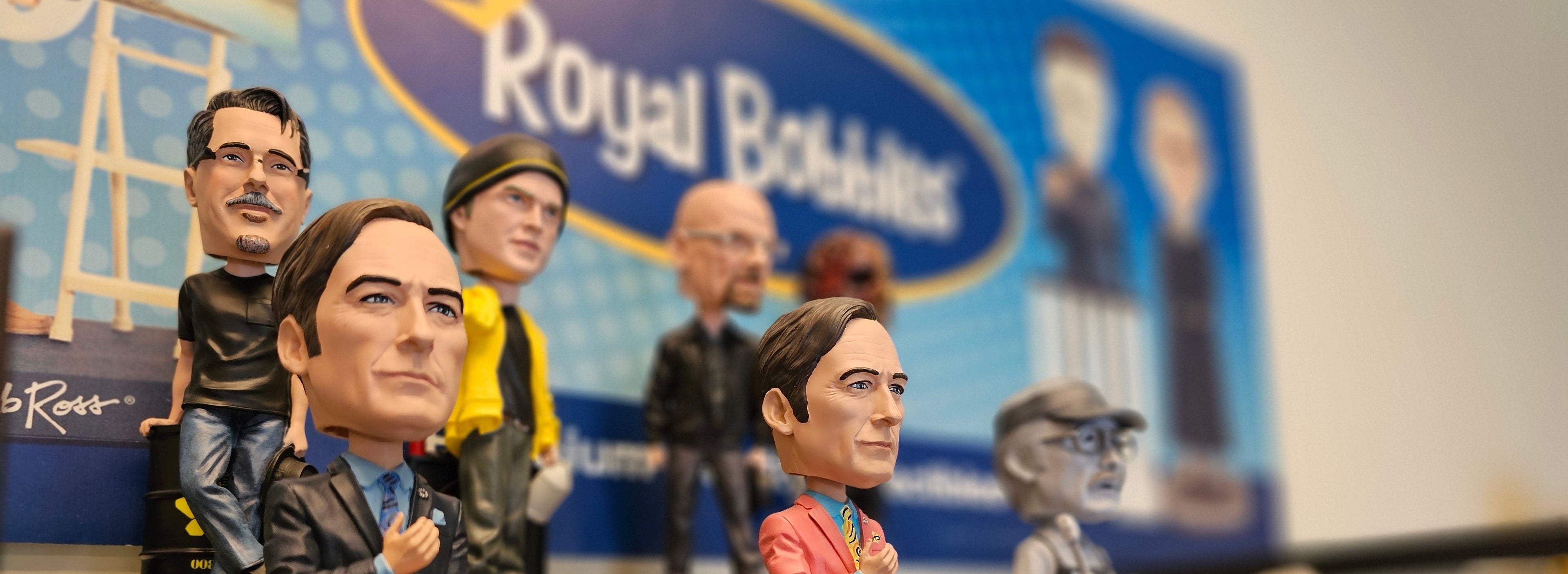 Bobbleheads on display shelf with Royal Bobbles sign in the background.