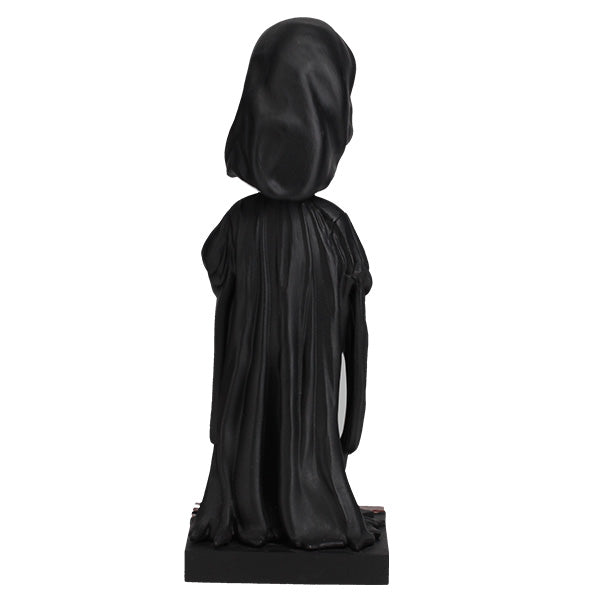 Black statue of a hooded figure on a white background