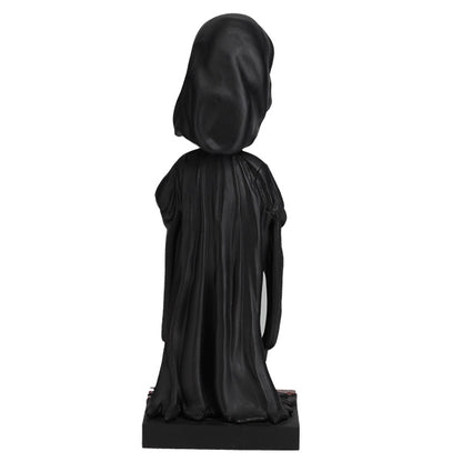 Black statue of a hooded figure on a white background