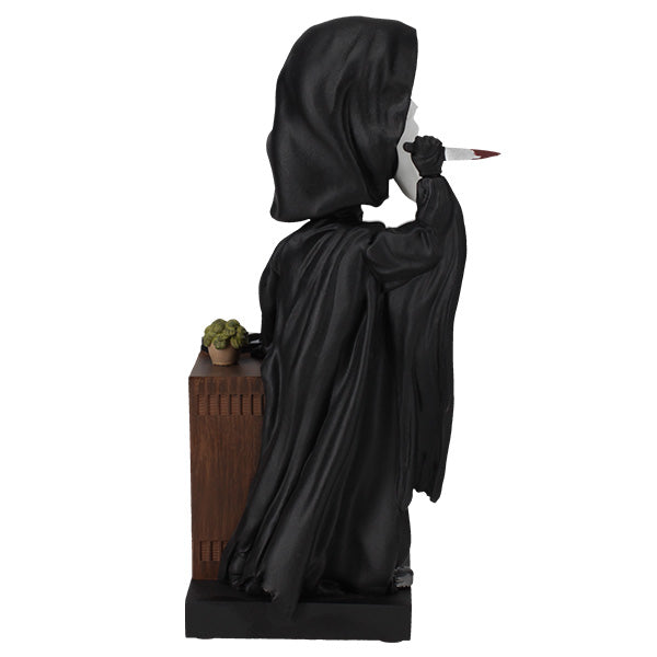 Statue of a hooded figure holding a sword on a white background