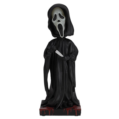 Statue of a character in a black hooded cloak with a white face mask on a white background