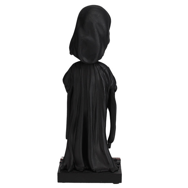 Black statue of a hooded figure on a white background