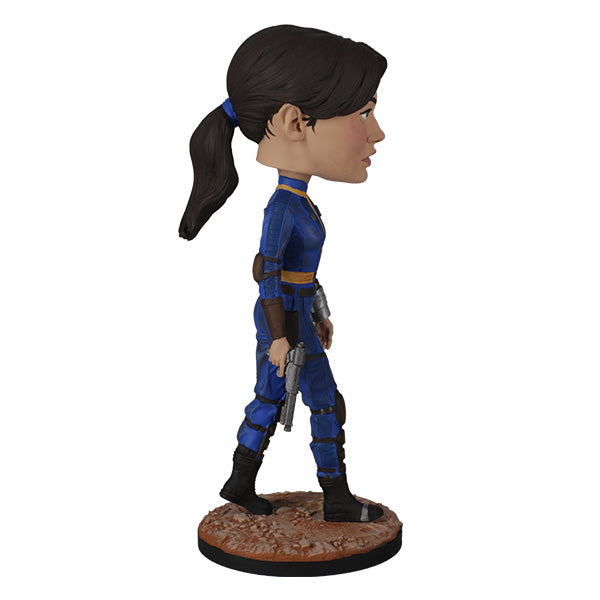 Action figure in blue and black outfit with a gun on a white background