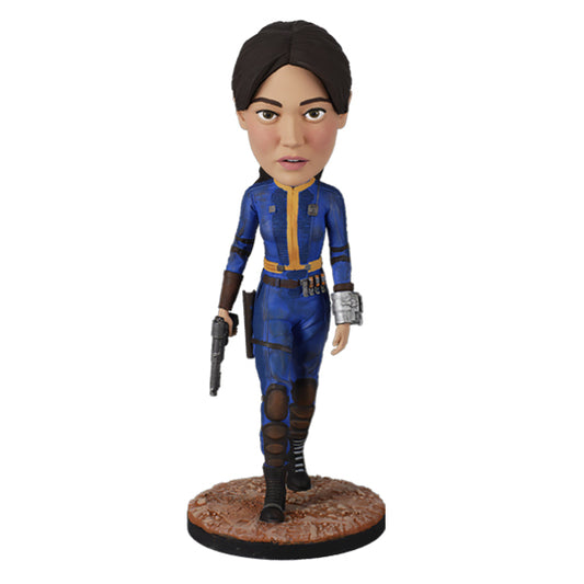 Action figure in blue and yellow jumpsuit holding a pistol on rugged base.