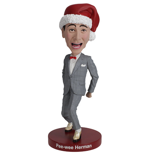 Pee-wee Herman bobblehead in gray suit and Santa hat on red base.