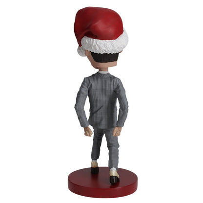 Back view Pee-wee Herman bobblehead in gray suit and Santa hat on red base.