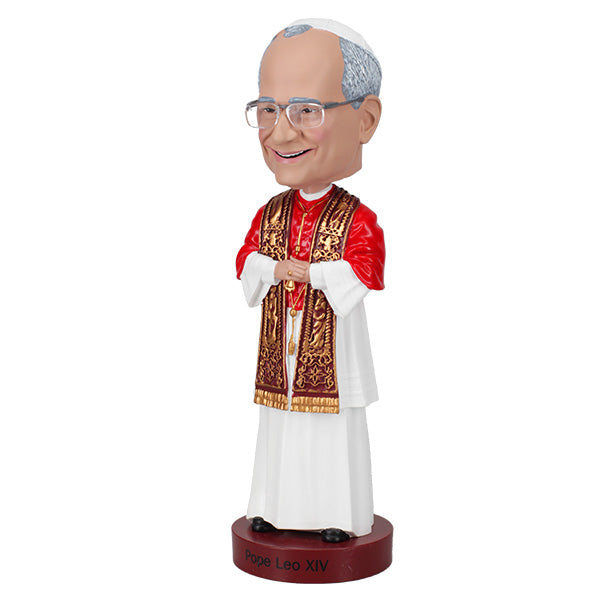 3/4 left side view of a bobblehead of a smiling figure in papal attire with a red cape and ornate gold stole, posed against a plain background, labeled "Pope Leo XIV."