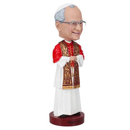 3/4 Right side view of a bobblehead of a smiling figure in papal attire with a red cape and ornate gold stole, posed against a plain background, labeled "Pope Leo XIV."